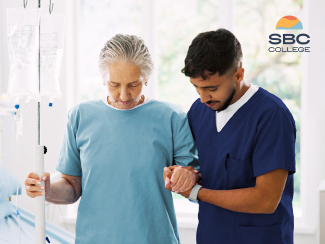 A Continuing Care Assistant helping a patient walk in a hospital setting.