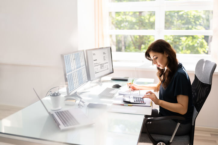 A freelancer who has completed an accounting diploma running numbers at her desk