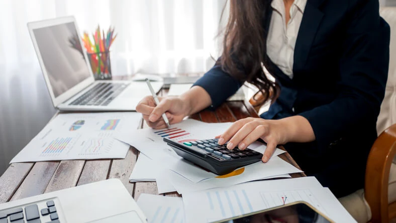 A freelancer who has completed an accounting diploma using a calculator.