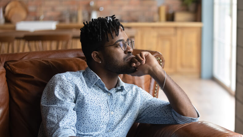 A man in career training sits on a chair while thinking.