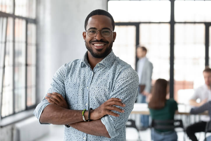 A male IT professional smiling in an office after completing corporate training