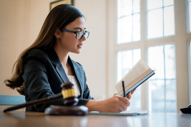 A female legal assistant writing in a notepad after legal assistant training