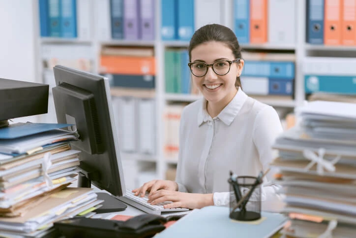 A career training graduate filing at a desk.