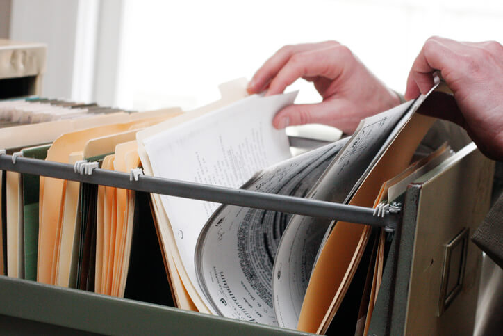 A career training graduate filing documents in an office