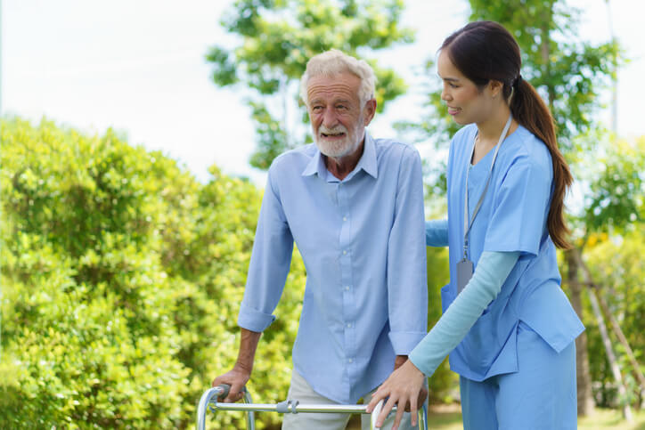 A female home support worker in a park with her client after completing home support worker training