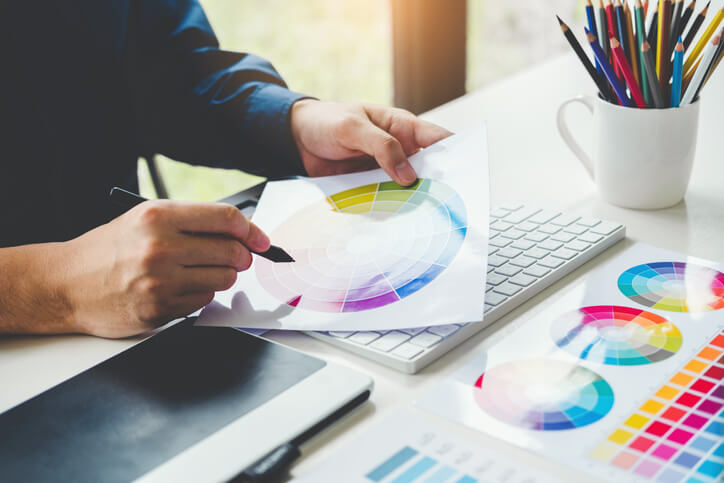 A male graphic designer drawing on a graphics tablet after completing his graphic design training