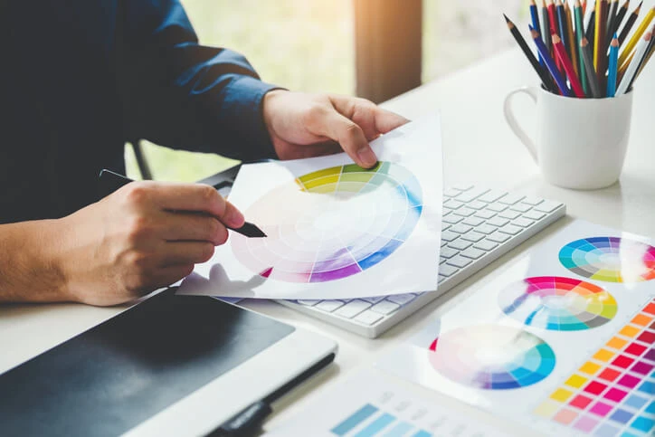 A graphic designer reviewing a colour wheel.