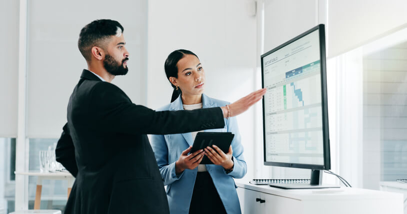 Two marketing professionals analyzing business data in an office after their business administration training