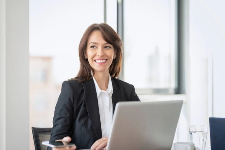 A cheerful executive administrative assistant sitting in an office at work.