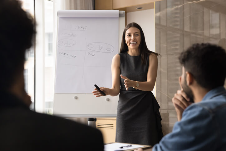 A female business professional delivering a presentation after completing her business administration training