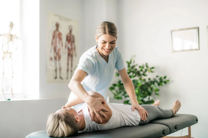 A home support worker helping a patient move.