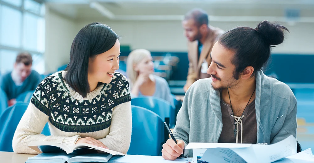 A student chatting with an instructor after class, highlighting the importance of professional networking in college.