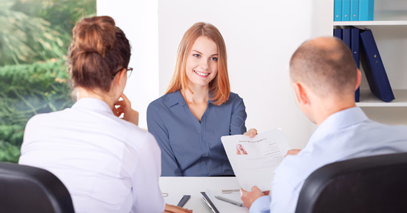 A job candidate answering common interview questions in an interview with hiring managers.