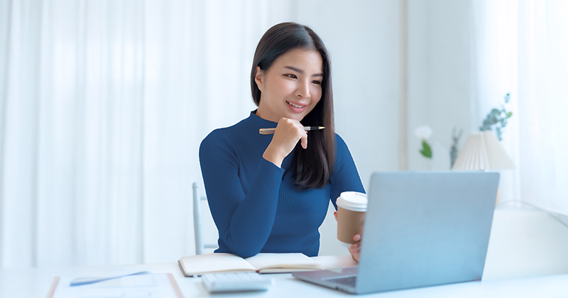 A young woman exploring career college programs on her laptop to prepare for a new career in the year ahead.