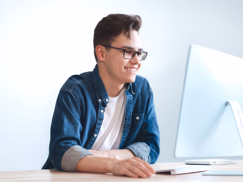 Smiling young man working at a computer.