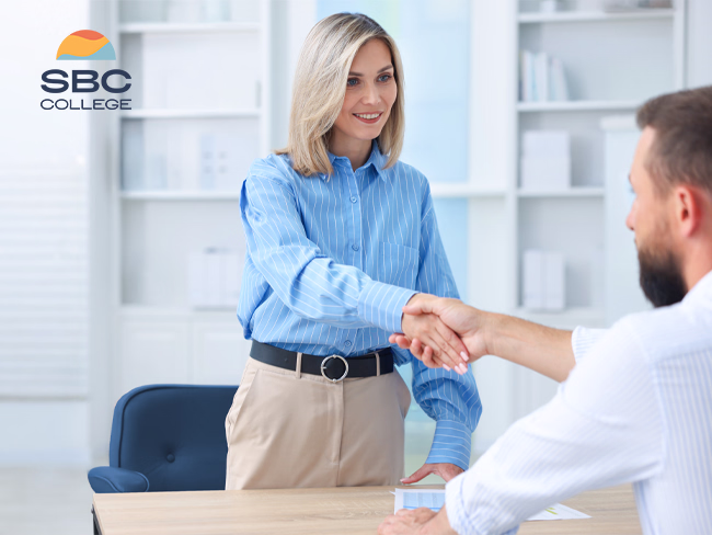 A female hospitality human resources coordinator shaking hands with a new employee during onboarding.