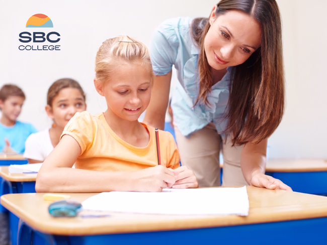 An education assistant helps an elementary-aged student with her work.