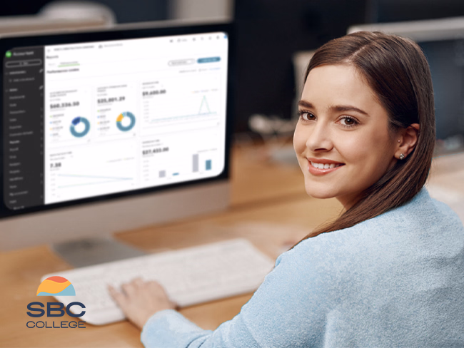 An accounting and payroll administrator uses QuickBooks software at her desk.